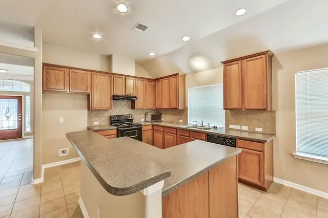 a kitchen with a sink stove and cabinets