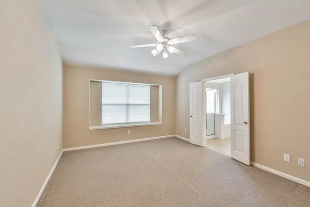 an empty room with fan and windows
