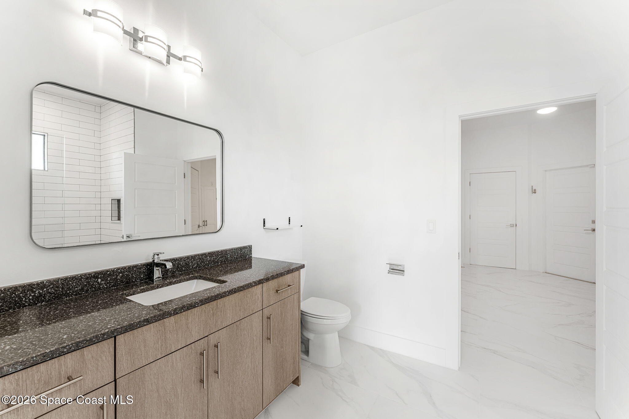 2355 North Riverside Drive Indialantic, FL 32903 - Photo 29 of 70 a bathroom with a granite countertop sink a toilet and a mirror