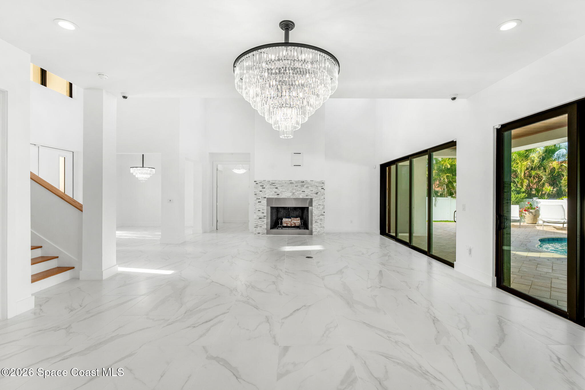 2355 North Riverside Drive Indialantic, FL 32903 - Photo 65 of 70 a view of an empty room with a fireplace and a chandelier