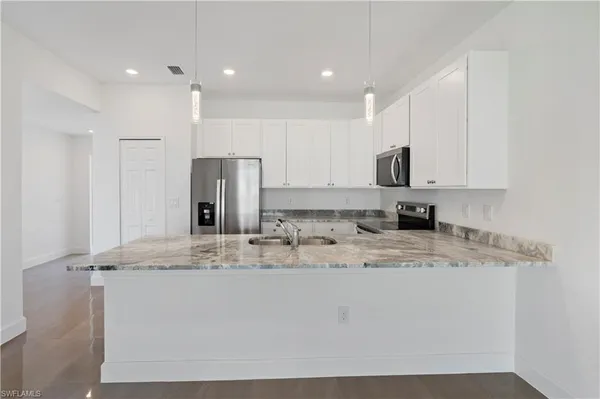 a kitchen with stainless steel appliances granite countertop a stove a sink and a refrigerator