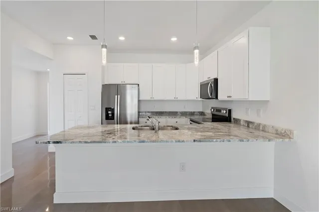 a kitchen with stainless steel appliances granite countertop a stove a sink and a refrigerator