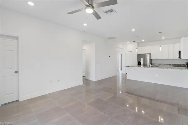 a view of kitchen with granite countertop stainless steel appliances white cabinets and a sink