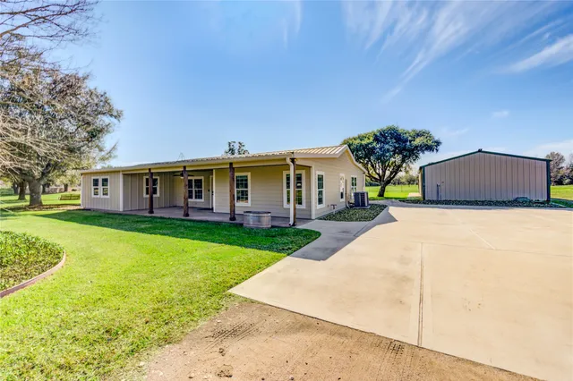 a front view of a house with a garden and yard