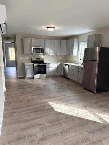 a kitchen with a refrigerator and a stove top oven