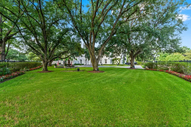 a view of grassy field with benches and trees all around