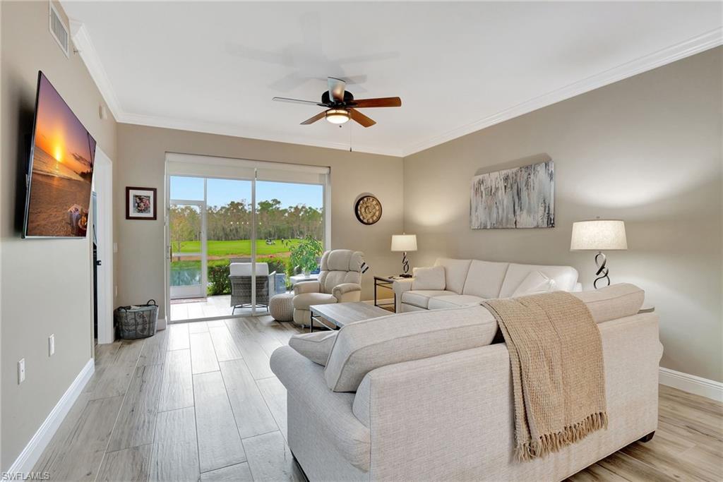 8630 Cedar Hammock Circle, Unit 1012 Naples, FL 34112 - Photo 15 of 37 a living room with furniture large window and a flat screen tv