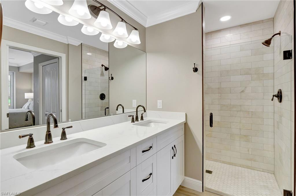 8630 Cedar Hammock Circle, Unit 1012 Naples, FL 34112 - Photo 21 of 37 a bathroom with a sink a double vanity and a mirror