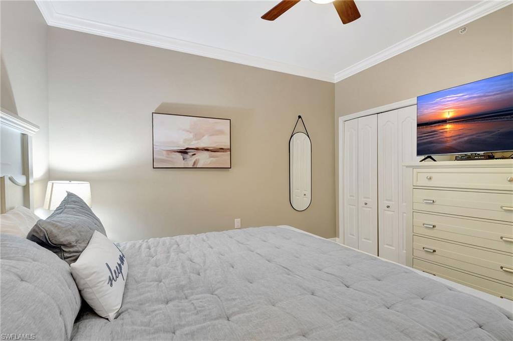 8630 Cedar Hammock Circle, Unit 1012 Naples, FL 34112 - Photo 23 of 37 a bedroom with a bed and a flat tv screen on dresser