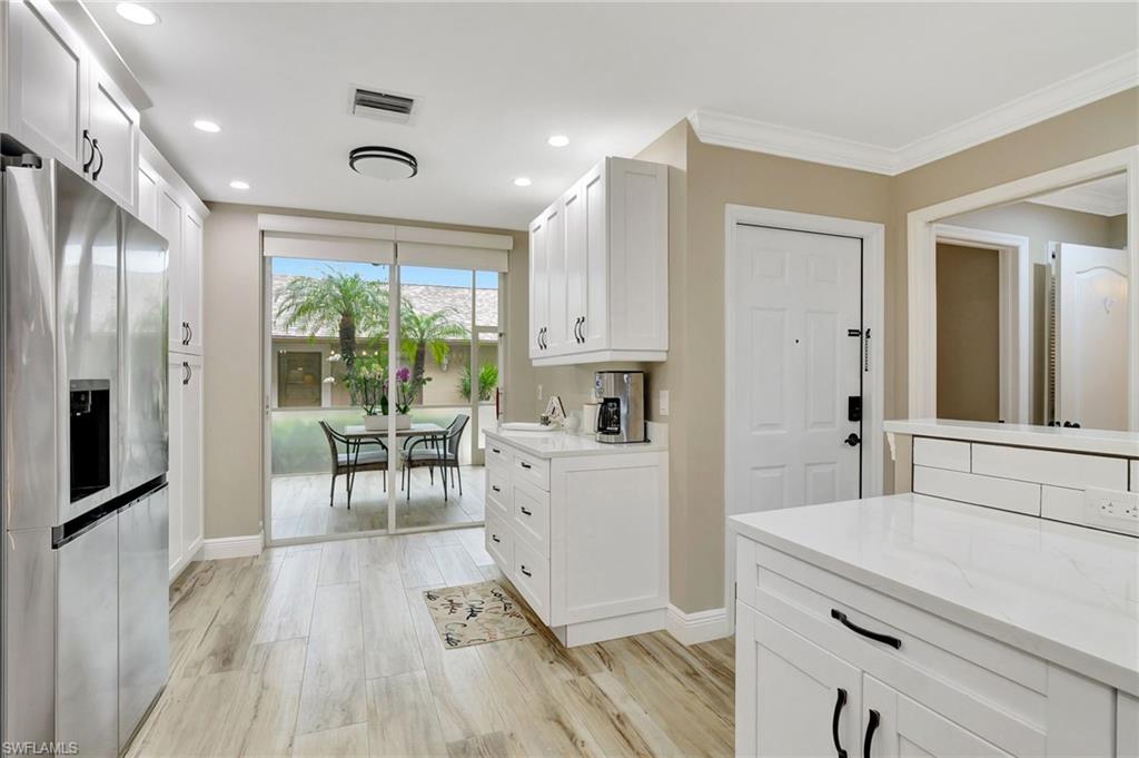 8630 Cedar Hammock Circle, Unit 1012 Naples, FL 34112 - Photo 5 of 37 a kitchen with a sink appliances and cabinets