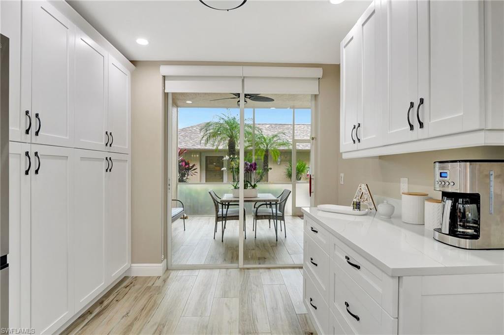 8630 Cedar Hammock Circle, Unit 1012 Naples, FL 34112 - Photo 6 of 37 a kitchen with a table chairs and a refrigerator