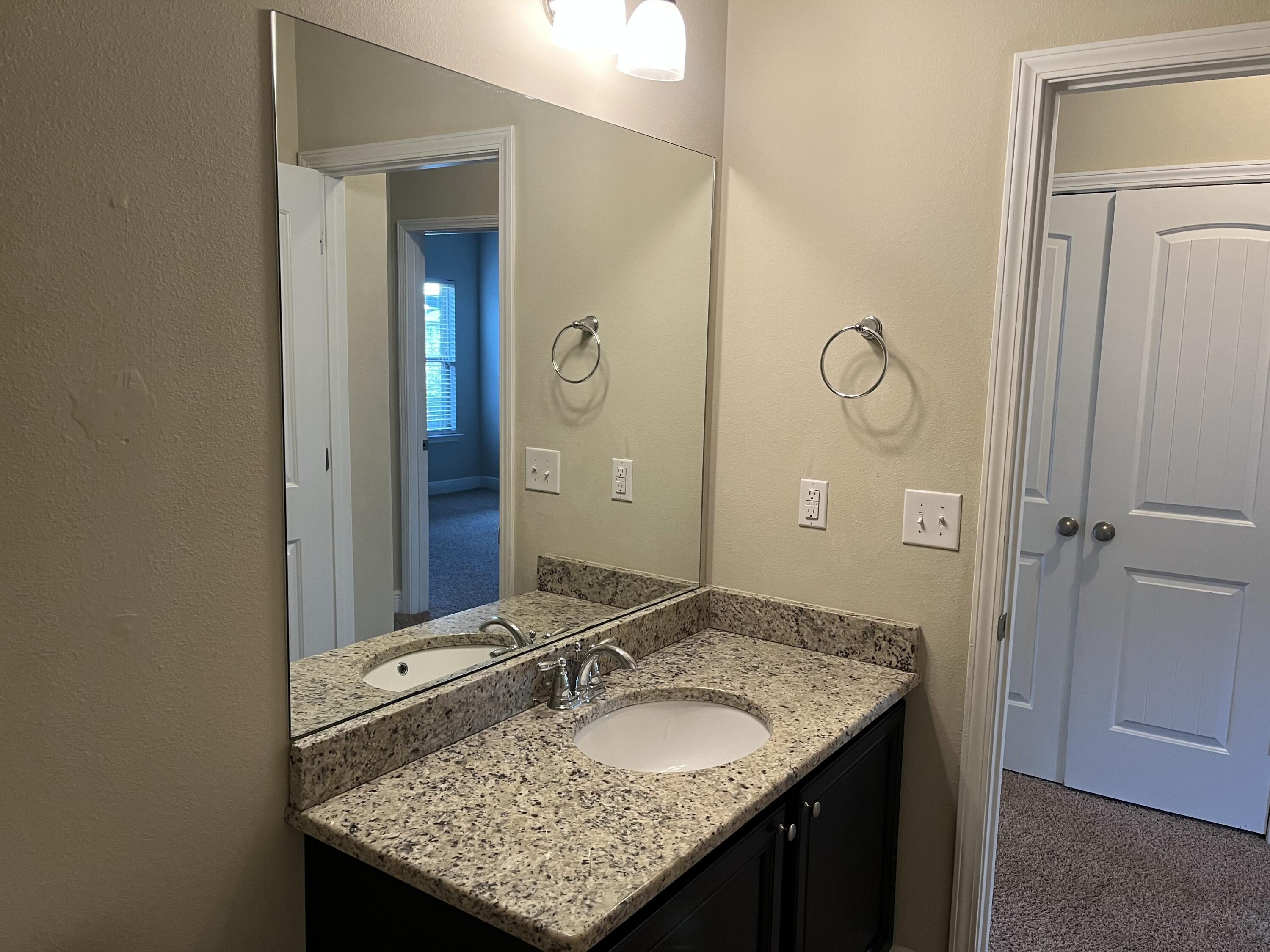 671 Teal Street Crestview, FL 32539 - Photo 10 of 22 a bathroom with a granite countertop sink and a mirror