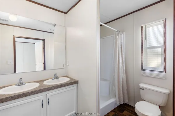 a bathroom with a granite countertop sink toilet and mirror