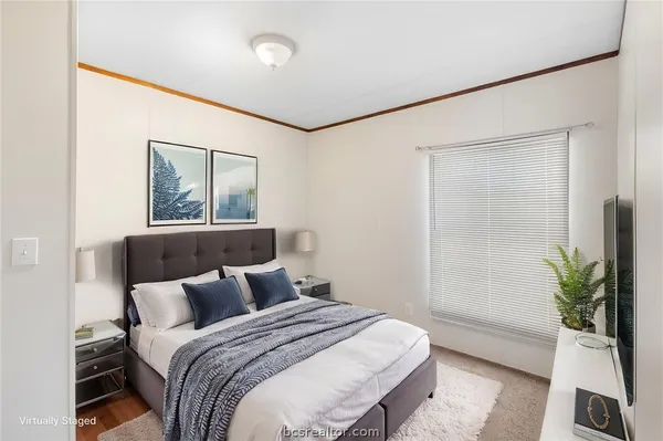 a bedroom with a bed and a potted plant
