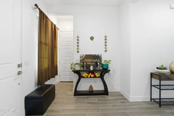 a view of a hallway with wooden floor and a bathroom