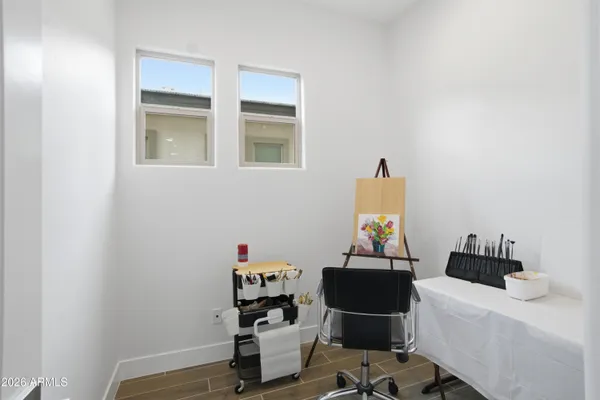 a view of a hallway with wooden floor and a bathroom