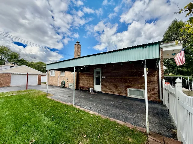 a view of a house with a yard and tree