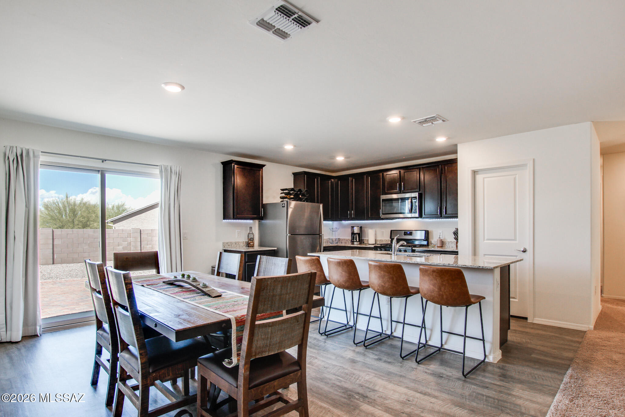 7056 South Draper Road Tucson, AZ 85757 - Photo 10 of 22 a dining room with kitchen island a table and chairs