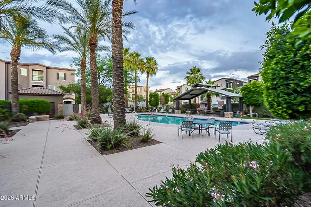 a view of a swimming pool with sitting area and garden