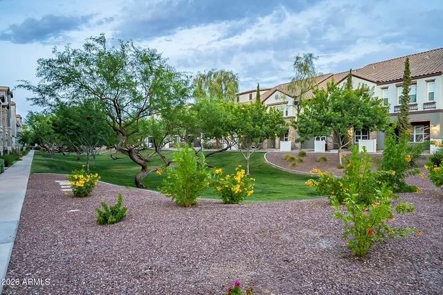 a view of a garden with a table and chairs under an umbrella