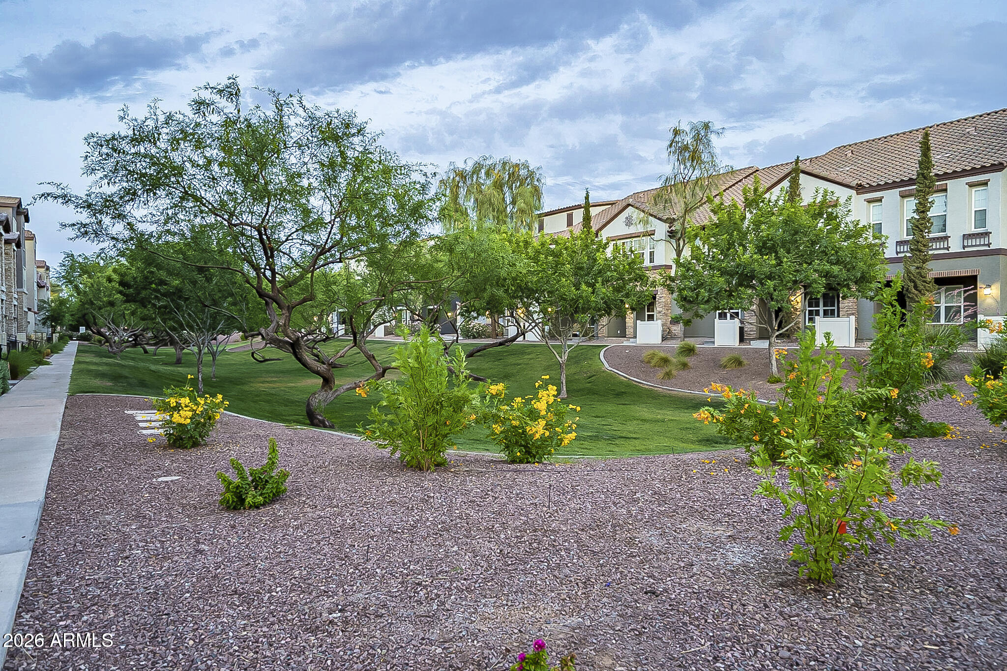 5851 South 23rd Way Phoenix, AZ 85040 - Photo 20 of 24 a view of a garden with a table and chairs under an umbrella
