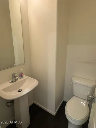 a bathroom with a toilet a sink and mirror
