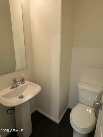a bathroom with a toilet a sink and mirror