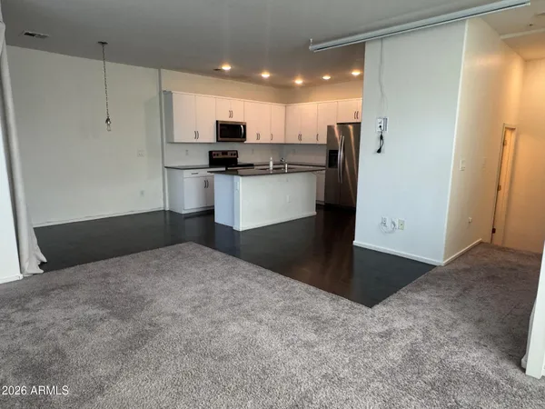 a kitchen with refrigerator and white cabinets