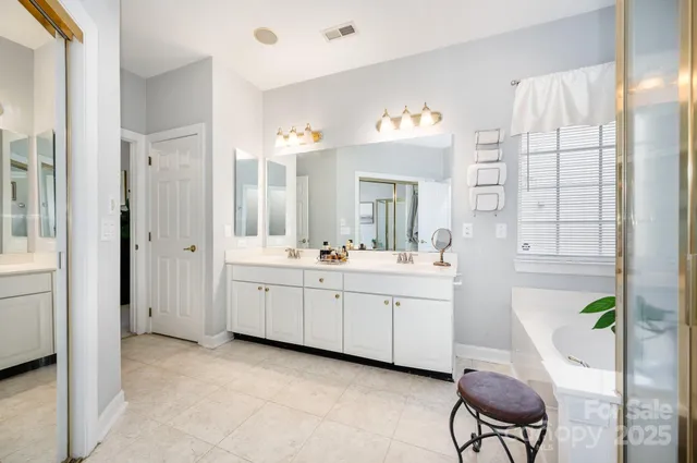 a spacious bathroom with a granite countertop sink mirror and a bathtub