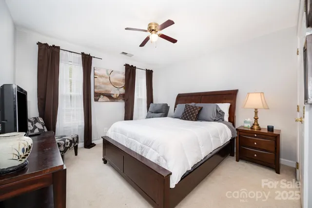 a spacious bedroom with a bed and a flat screen tv