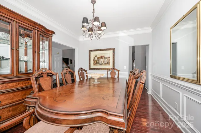 a view of a dining room with furniture a chandelier and large windows