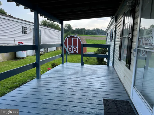 a view of a deck with wooden floor and floor to ceiling window