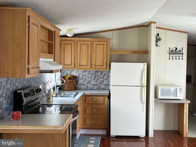 a kitchen with a refrigerator and a stove top oven