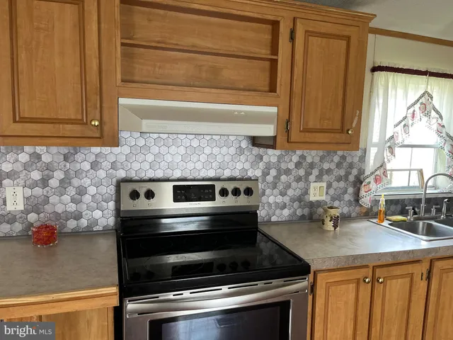 a kitchen with granite countertop a stove and a sink