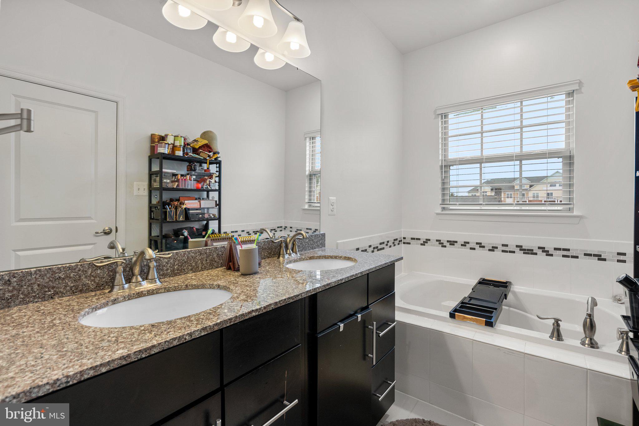14407 Sandy Ridge Lane Laurel, MD 20707 - Photo 19 of 29 a bathroom with a granite countertop sink a large mirror and a window