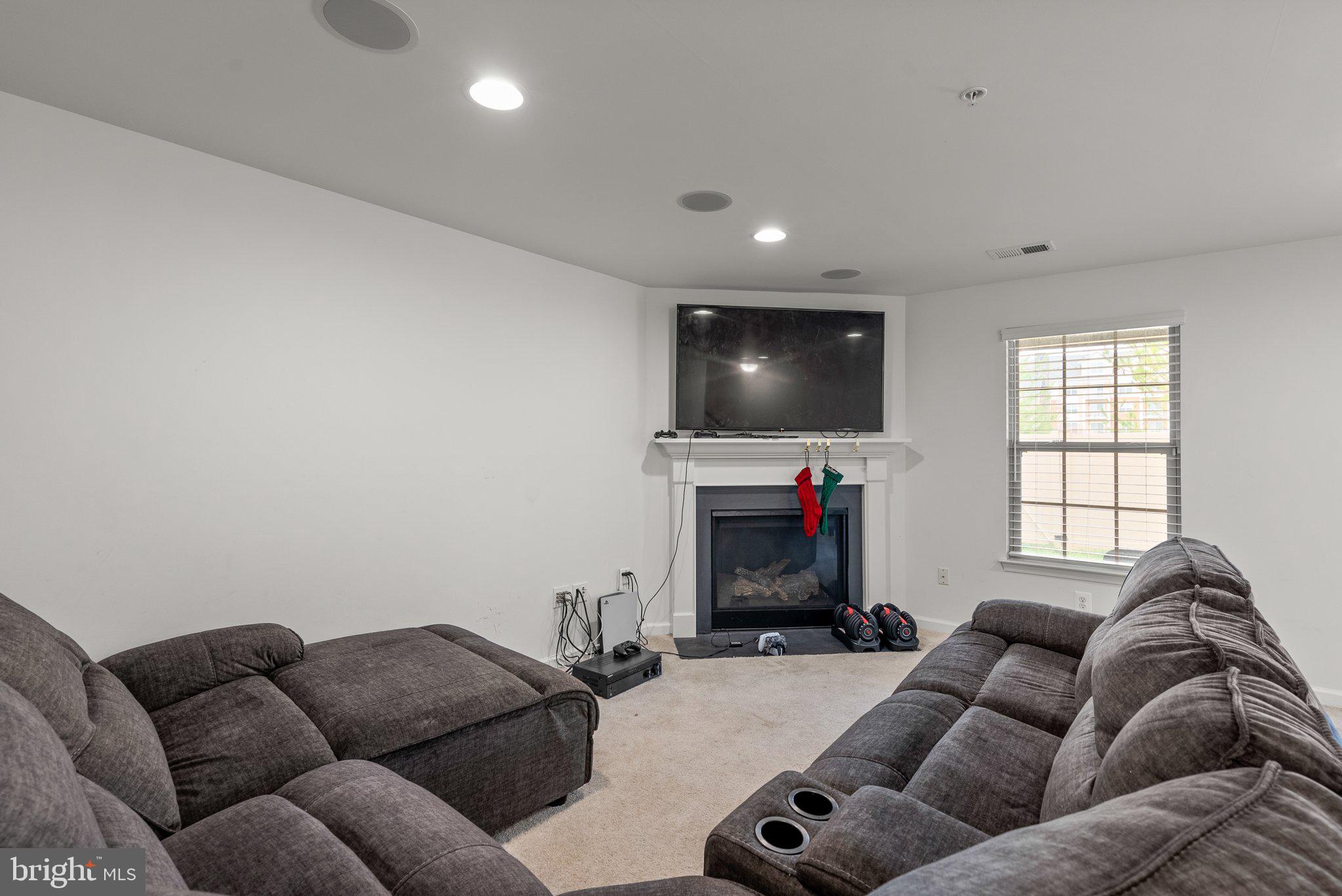 14407 Sandy Ridge Lane Laurel, MD 20707 - Photo 22 of 29 a living room with furniture a flat screen tv and a fireplace