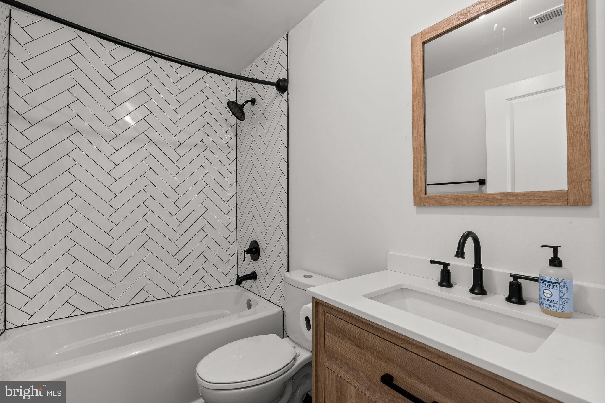 14407 Sandy Ridge Lane Laurel, MD 20707 - Photo 25 of 29 a bathroom with a sink a toilet and shower