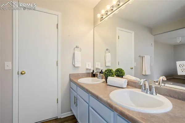 a bathroom with double vanity sinks and a mirror