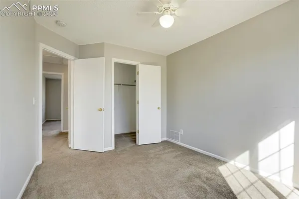 an empty room with windows and closet
