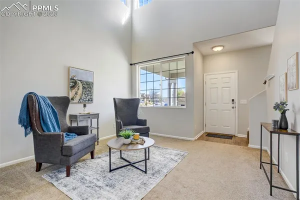 a living room with furniture a rug and a large window