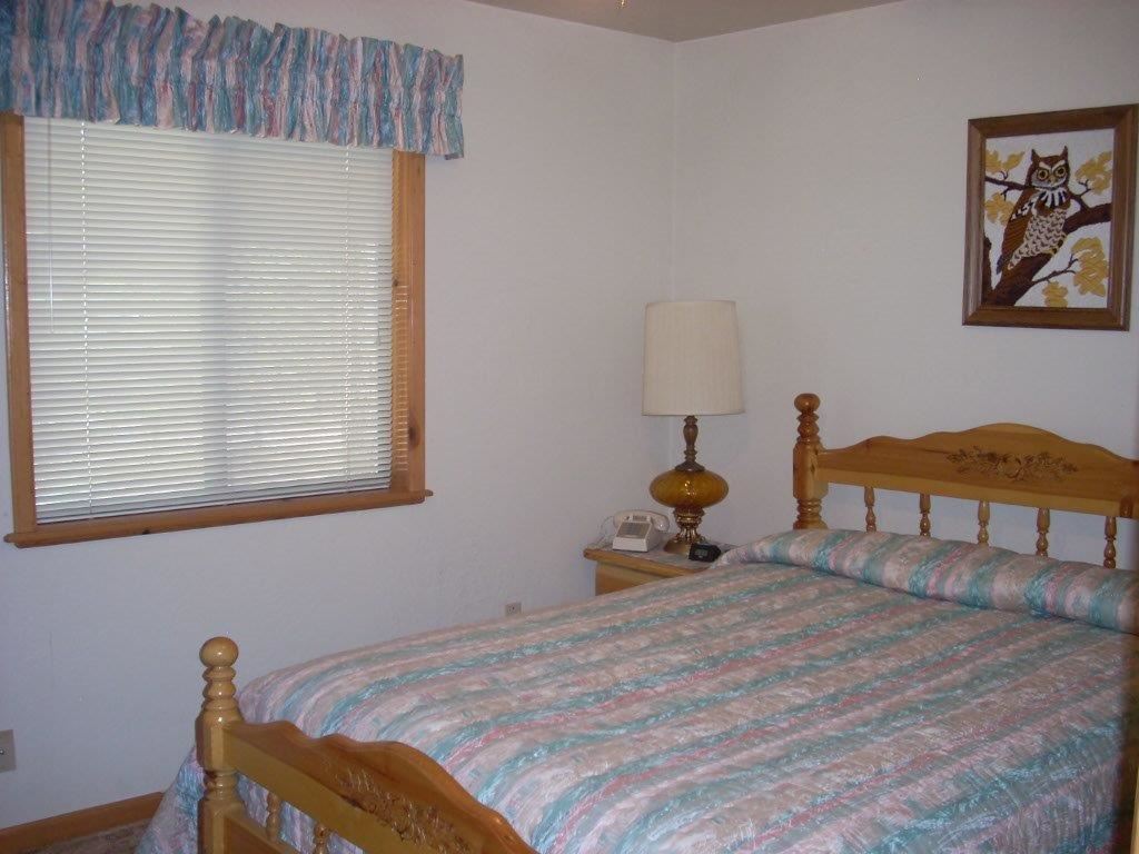 2923 Markham Road Overgaard, AZ 85933 - Photo 17 of 33 a bed room with a bed and a lamp
