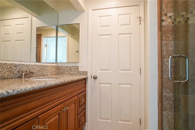 a bathroom with a granite countertop sink and a mirror