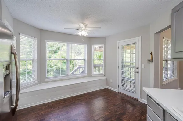 an empty room with wooden floor closet and fan