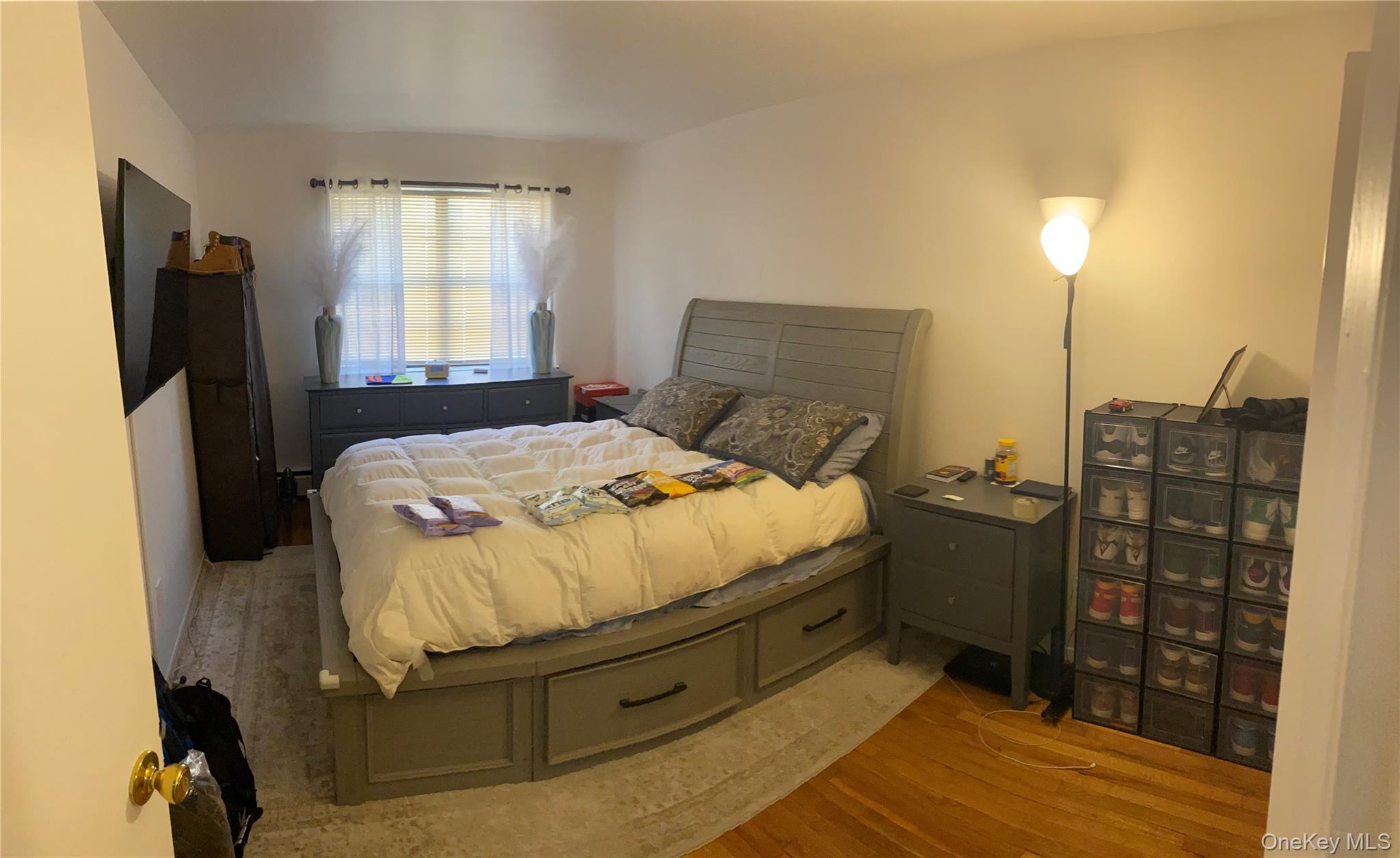 84-24 98th Street, Unit 1 Queens, NY 11421 - Photo 3 of 22 a bedroom with a bed and a flat tv screen on the dresser