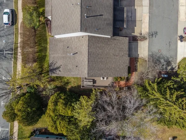 aerial view of a house with a yard and large tree