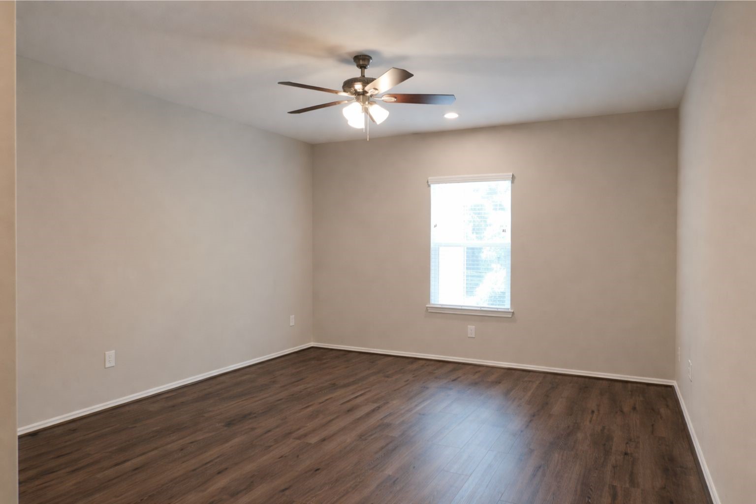 1100 Mann Road Conroe, TX 77303 - Photo 12 of 16 a view of an empty room with wooden floor and a window