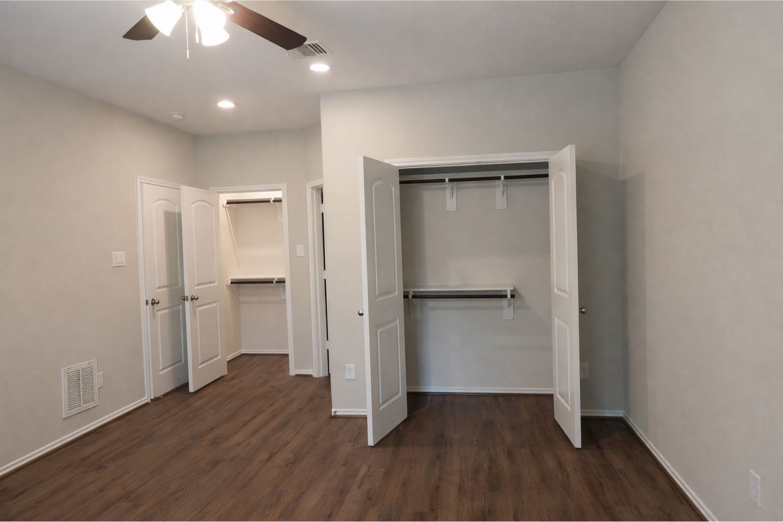 1100 Mann Road Conroe, TX 77303 - Photo 13 of 16 an empty room with wooden floor a ceiling fan and entryway