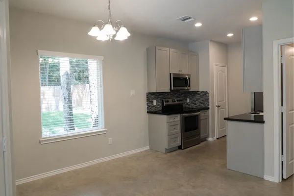 a kitchen with kitchen island granite countertop a stove cabinets and a refrigerator