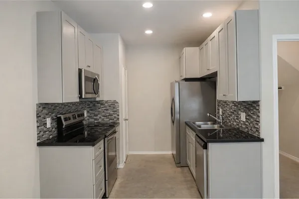 a kitchen with stainless steel appliances a refrigerator and a stove top oven