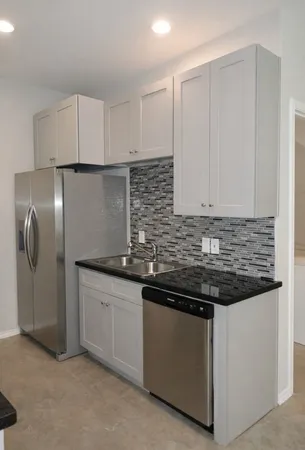 a kitchen with stainless steel appliances granite countertop a sink and a refrigerator